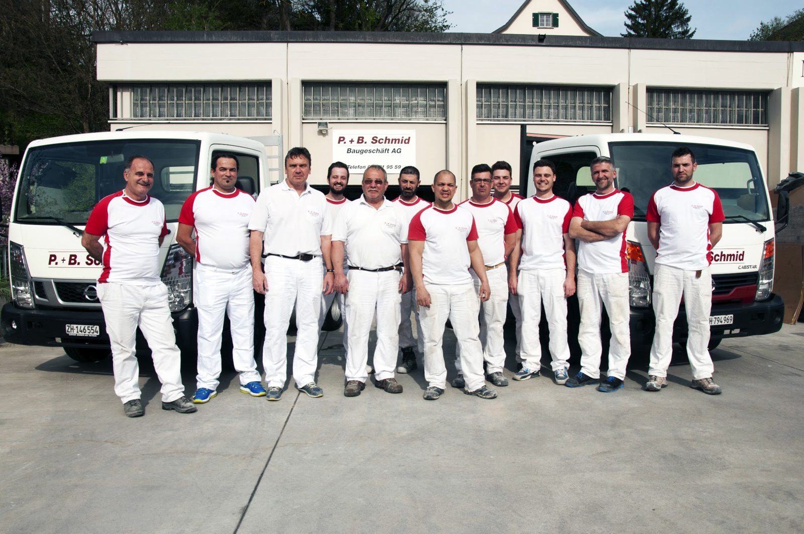 Das Team der P. + B. Schmid Baugeschäft AG vor den Firmenfahrzeugen beim Werkhof in Adliswil